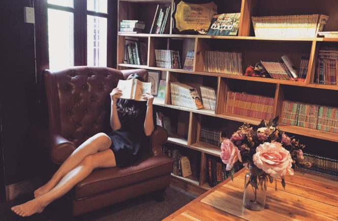 Canva - Woman Reading Book in the Library